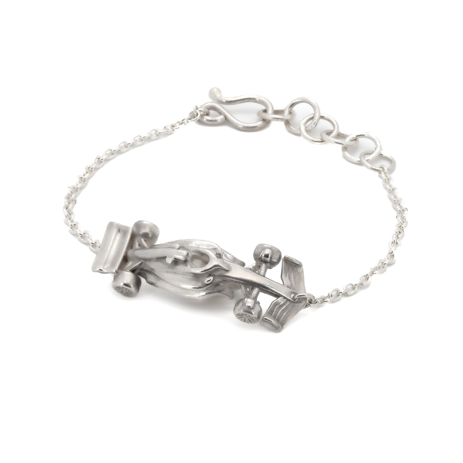 Taru Jewelry Race Car Bracelet is a stunning piece that captures the essence of speed and adrenaline. Crafted from sterling silver, this bracelet features a sleek and aerodynamic race car design complete with intricate details. The streamlined body of the car creates a sense of movement and energy. The wheels of the car are finely detailed and perfectly balanced, ready to take on any race course. The curvature of the car allows the bracelet to hug around the contours of the wrist perfectly.