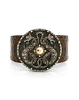 Taru Jewelry Dragon Shield Bracelet is a bold piece crafted from 18K gold and sterling silver. Featuring a majestic design of two dragons, it is adorned with brown rosecut diamonds and black diamonds.