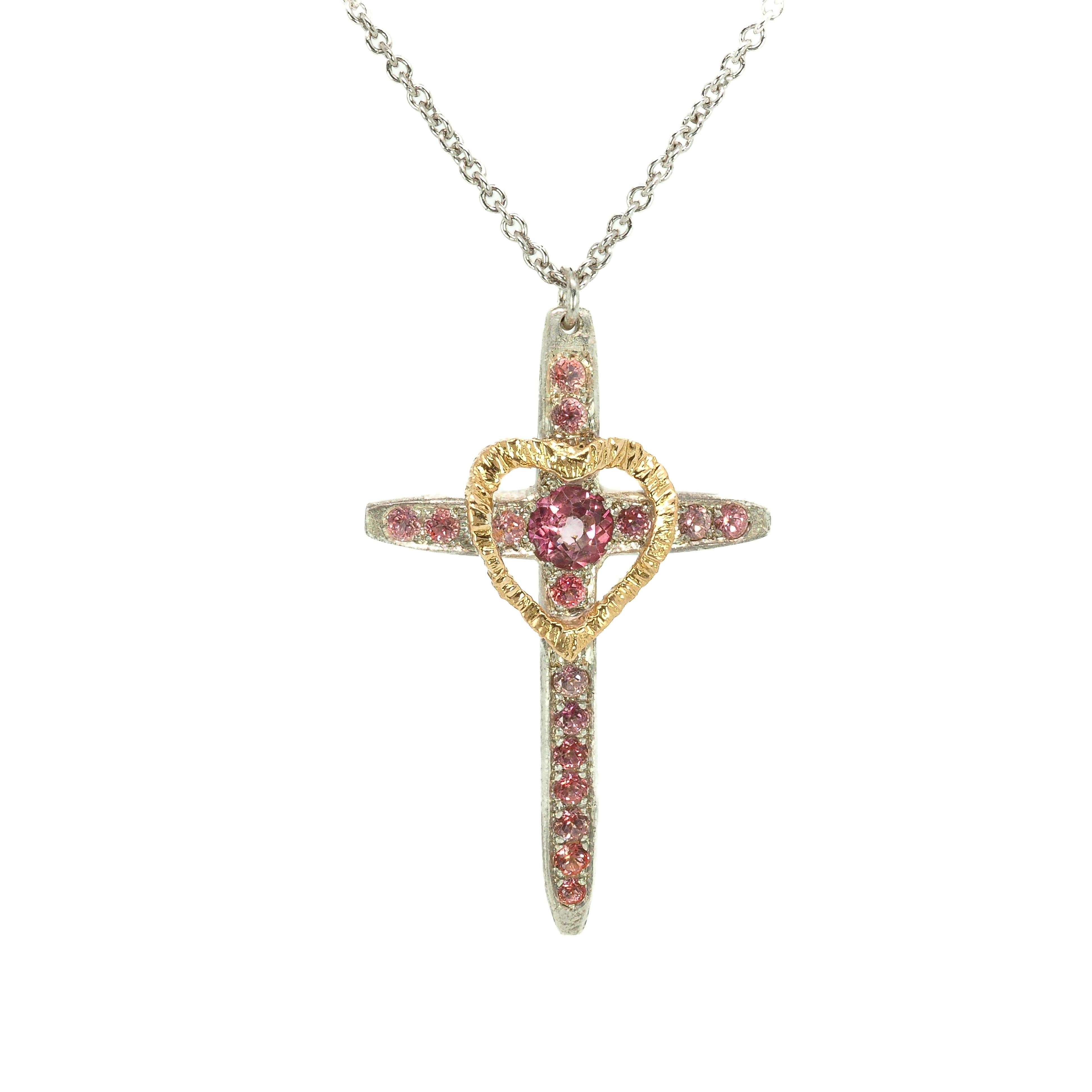 Taru Jewelry Cross and Heart Necklace crafted from 18K gold and silver is a unique blend of traditional and modern design. The cross, a timeless symbol of faith and devotion, is adorned with beautiful pink topaz, adding a touch of color and elegance to the piece.