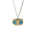 Taru Jewelry captivating owl necklace, crafted from 18K gold and sterling silver, captures the essence of the wise and mysterious bird. The owl's eyes are set with sparkling blue topaz, adding a touch of color and elegance to the piece. The blue topaz represents loyalty, righteousness, and the ability to improve communication and find the perfect pathways to success.